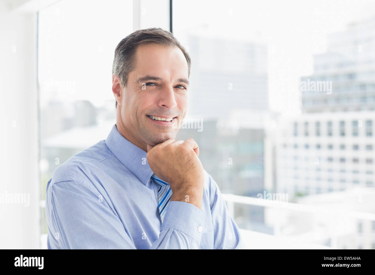 Smiling businessman looking at camera Stock Photo - Alamy