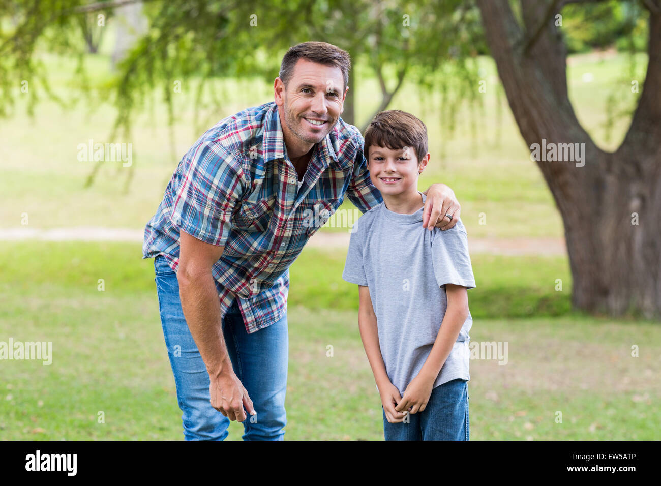 father and son smiling at camera in the park Stock Photo - Alamy