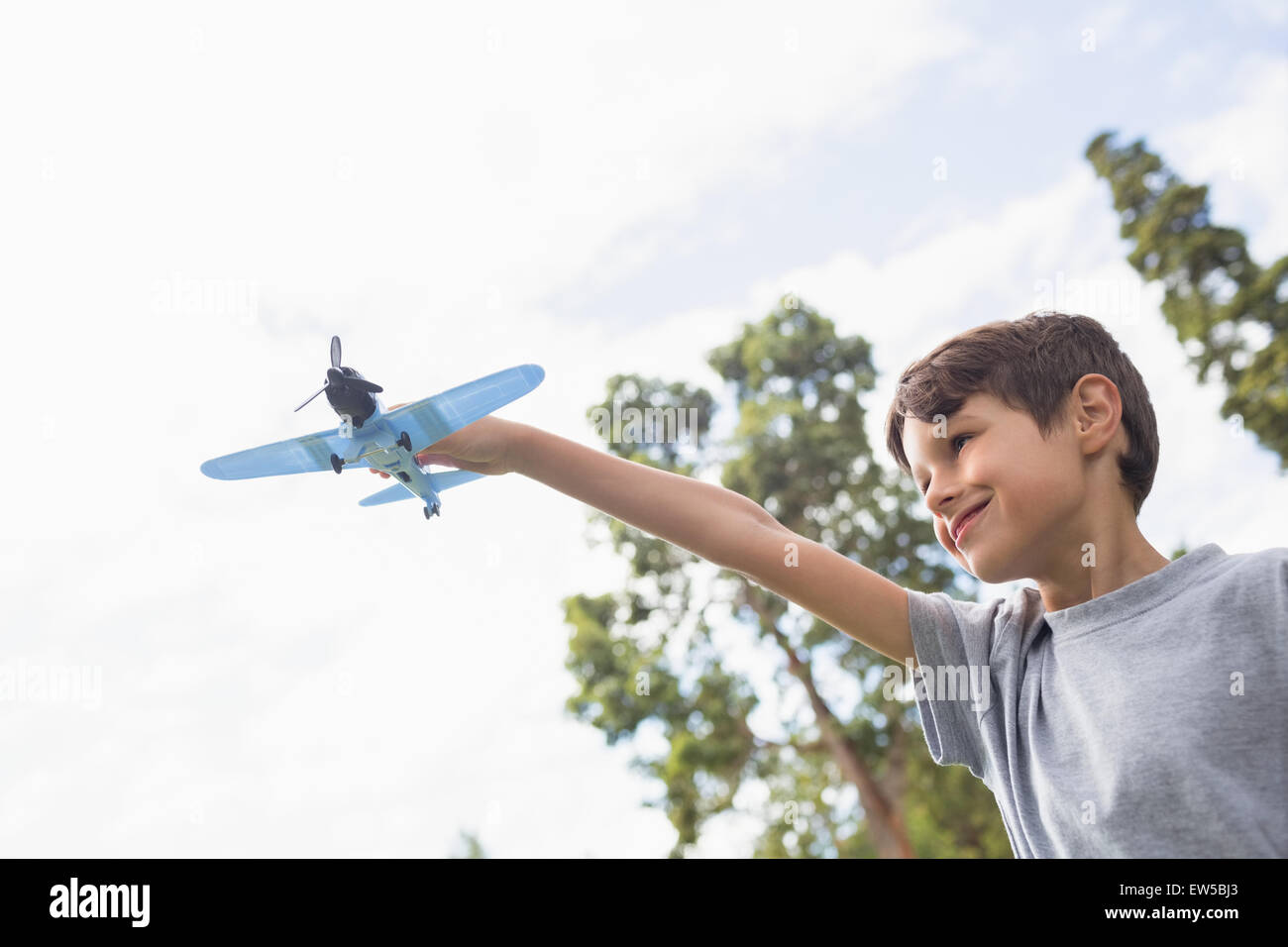 Boy playing with a toy plane at park Stock Photo - Alamy