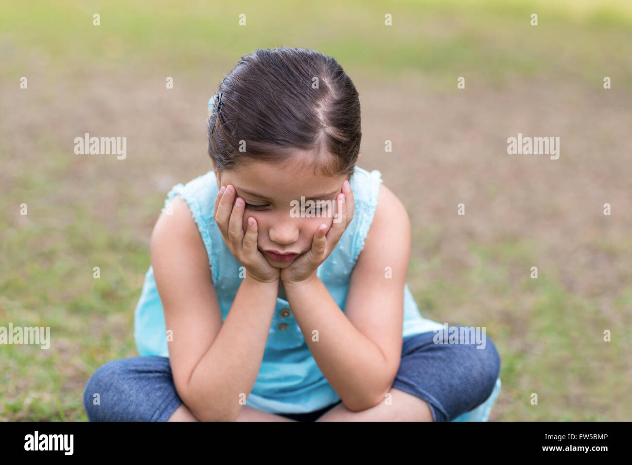 Little boy feeling sad in the park Stock Photo