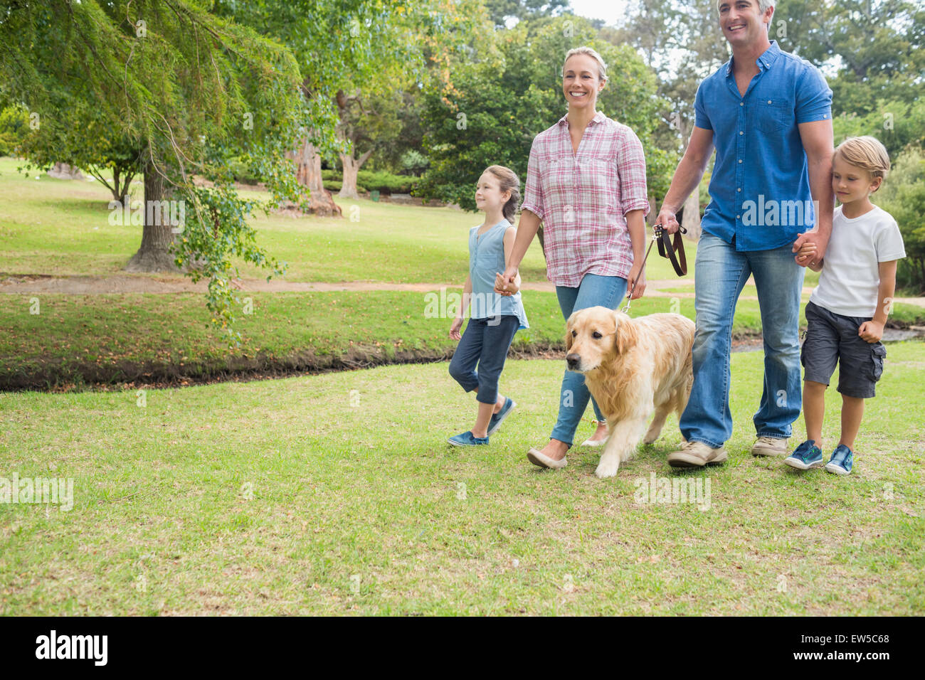 Happy family in the park with their dog Stock Photo