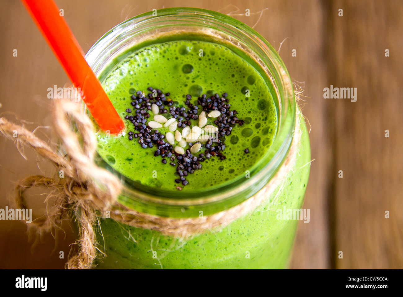 Green vegetable and herbs smoothie with heart of poppy and sesame seeds