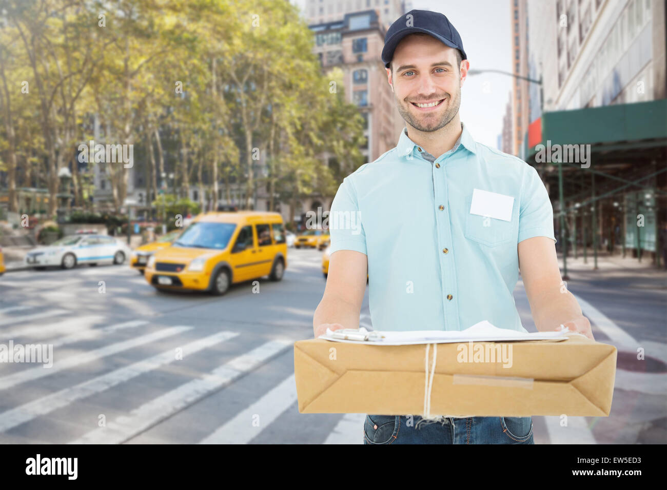 Composite image of handsome courier man with parcel Stock Photo