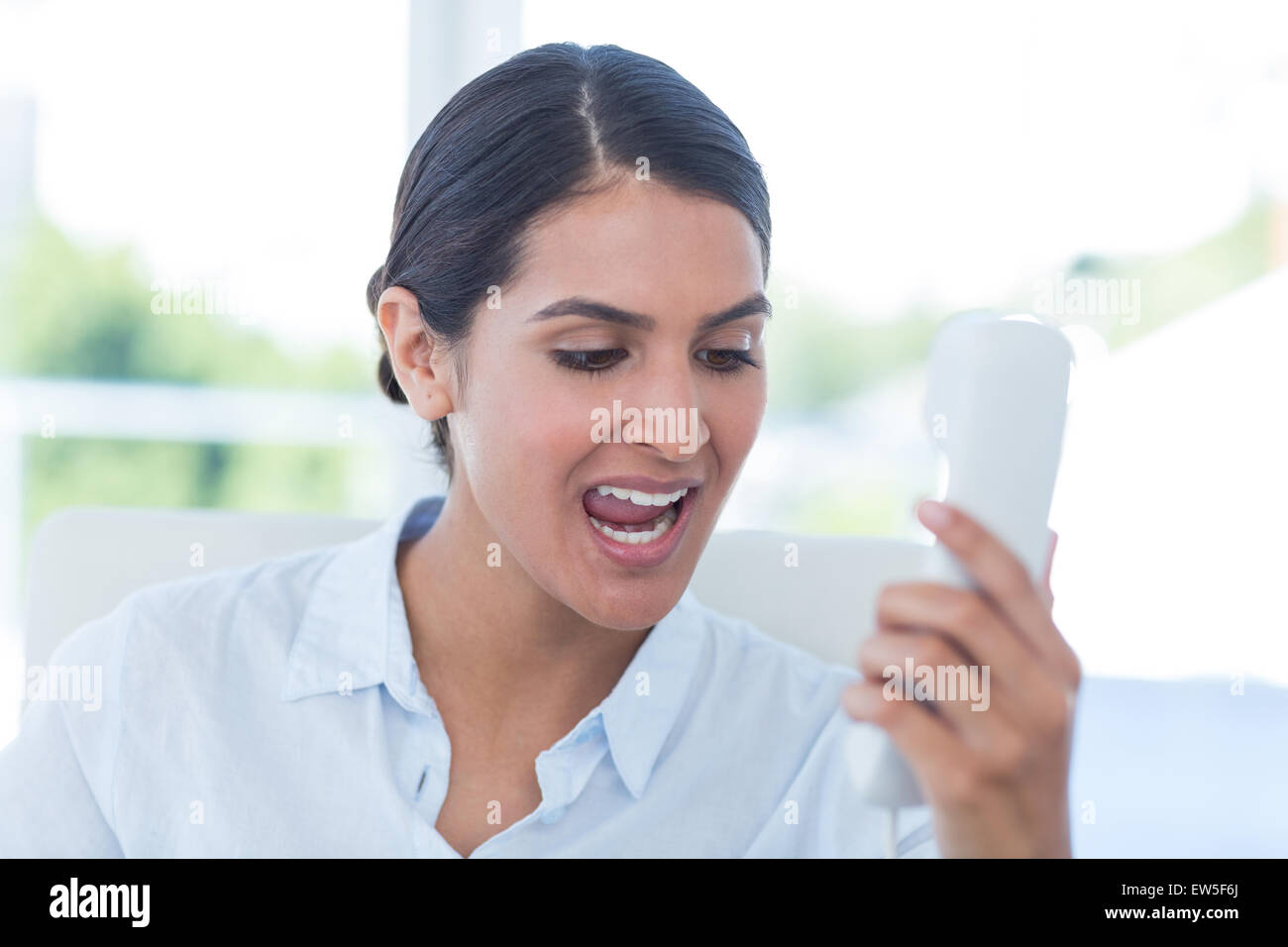 Businesswoman yelling at her phone Stock Photo