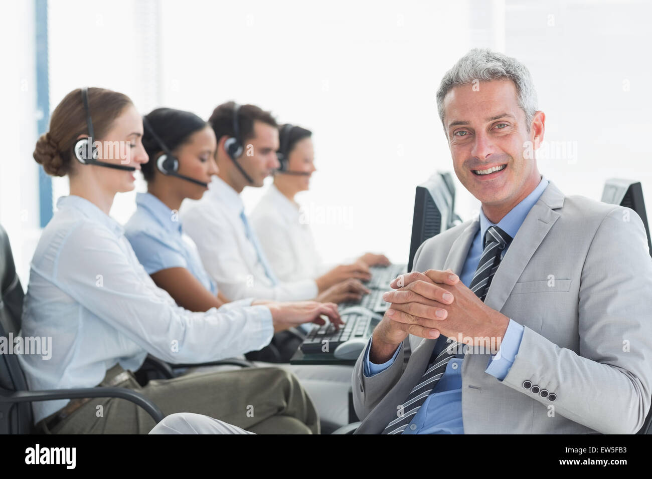 Businessman with executives using computers Stock Photo - Alamy