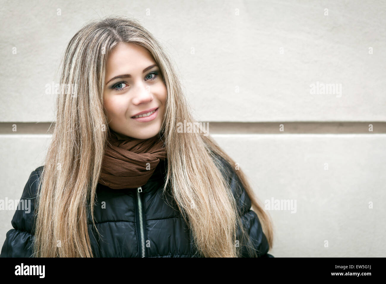 Portrait of a young woman and wall in background Stock Photo - Alamy
