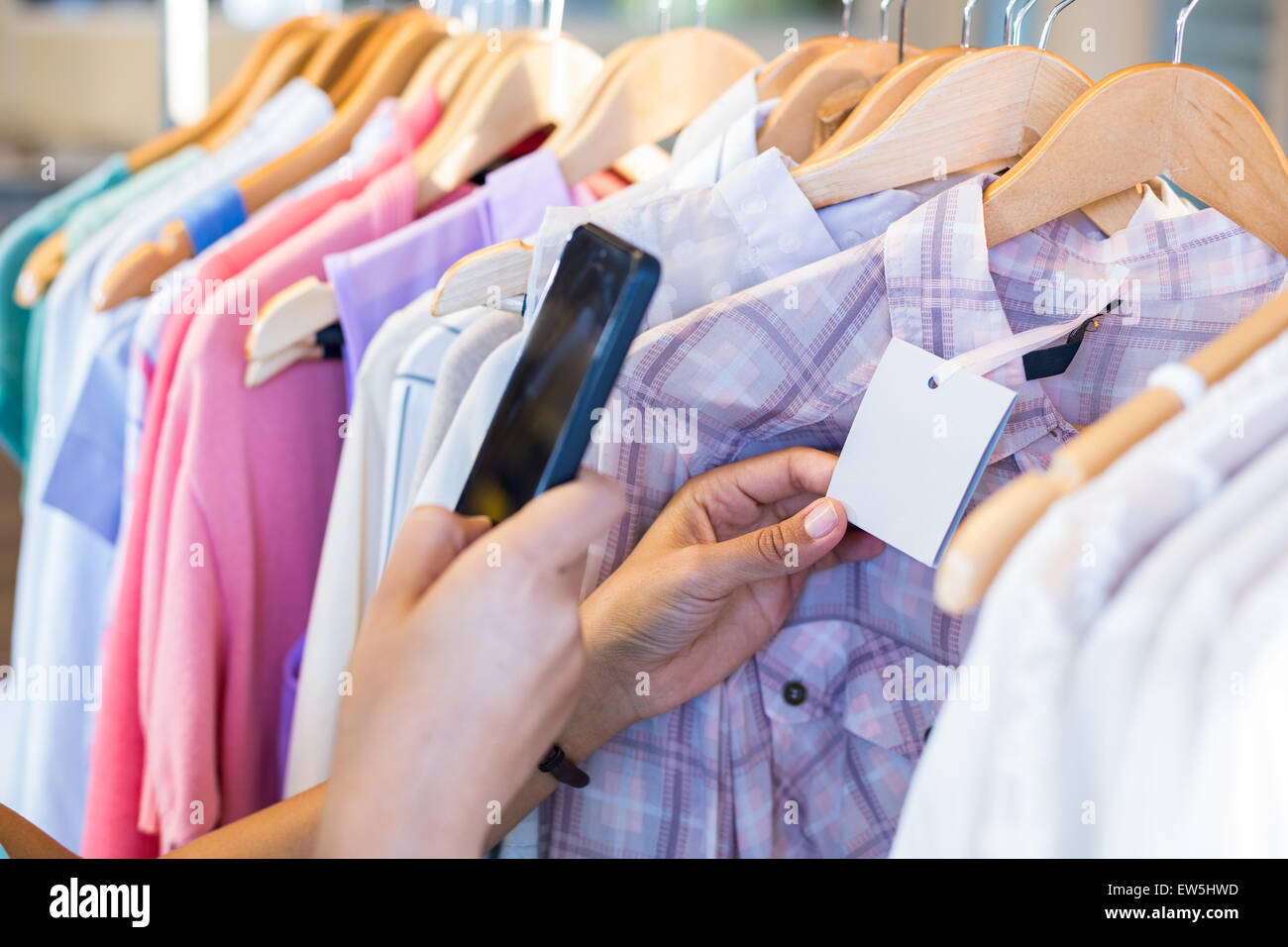 Woman scanning bar code with her mobile phone Stock Photo