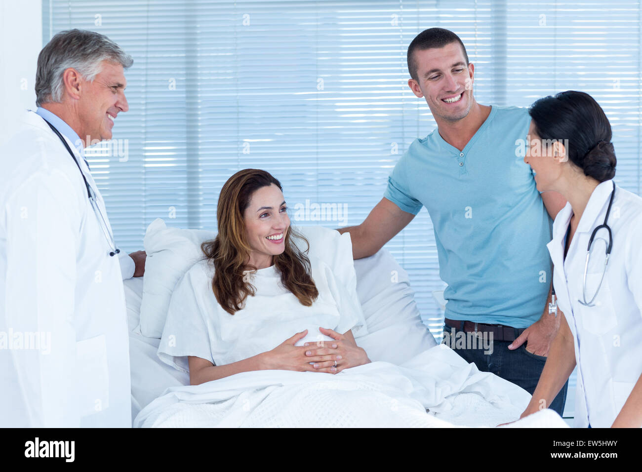 Future parents talking with smiling doctors Stock Photo