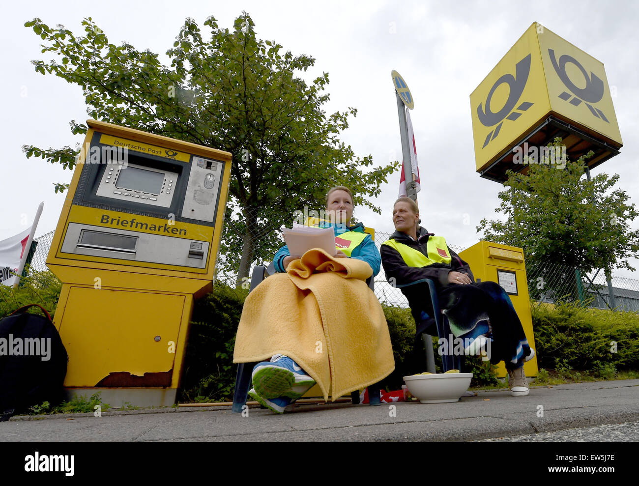 Striking postal workers sit in front of a post distribution center in Kiel, Germany, 18 June 2015. The ver.di trade union is increasing the pressure in the conflict with the Deutsche Post AG and has called further sectors of the postal service to an open- Stock Photo