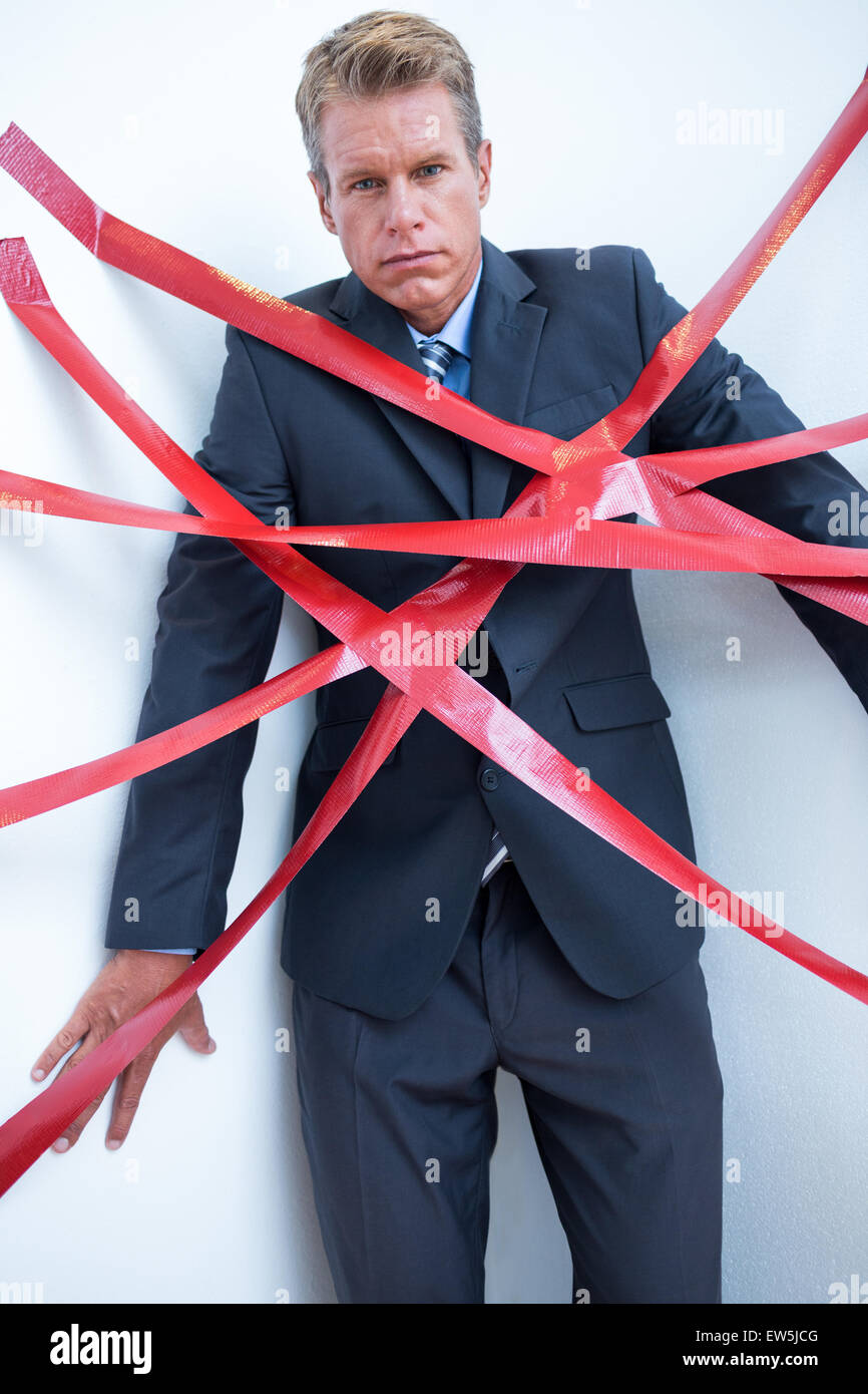 Businessman trapped by red tape Stock Photo