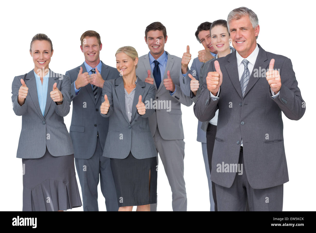Smiling business team showing thumbs up Stock Photo - Alamy