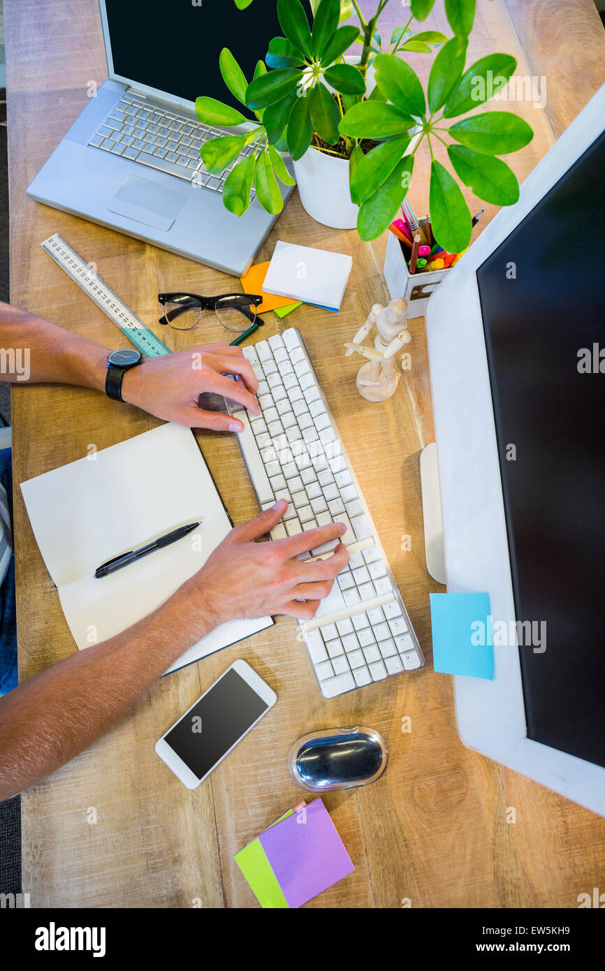 Man working at his desk and typing on keyboard Stock Photo