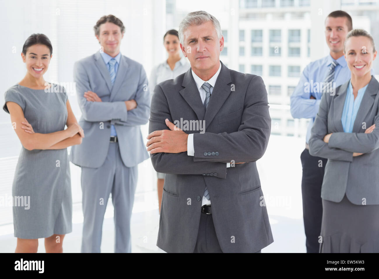 Smiling business team standing with arms crossed Stock Photo - Alamy