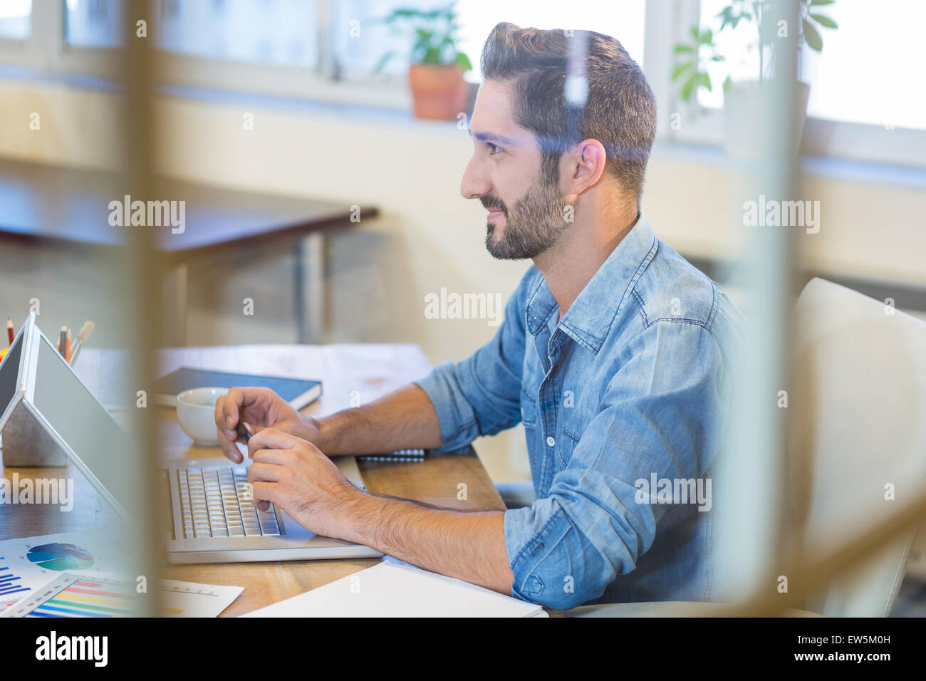 Smiling businessman working on laptop Stock Photo