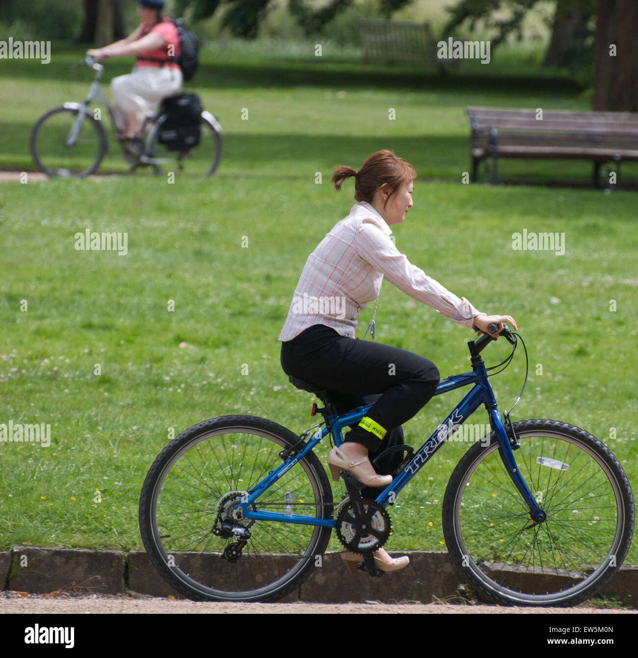 Two women cycling in a park Stock Photo Alamy