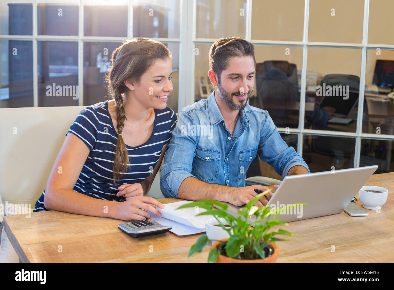 Partners working at desk using laptop Stock Photo