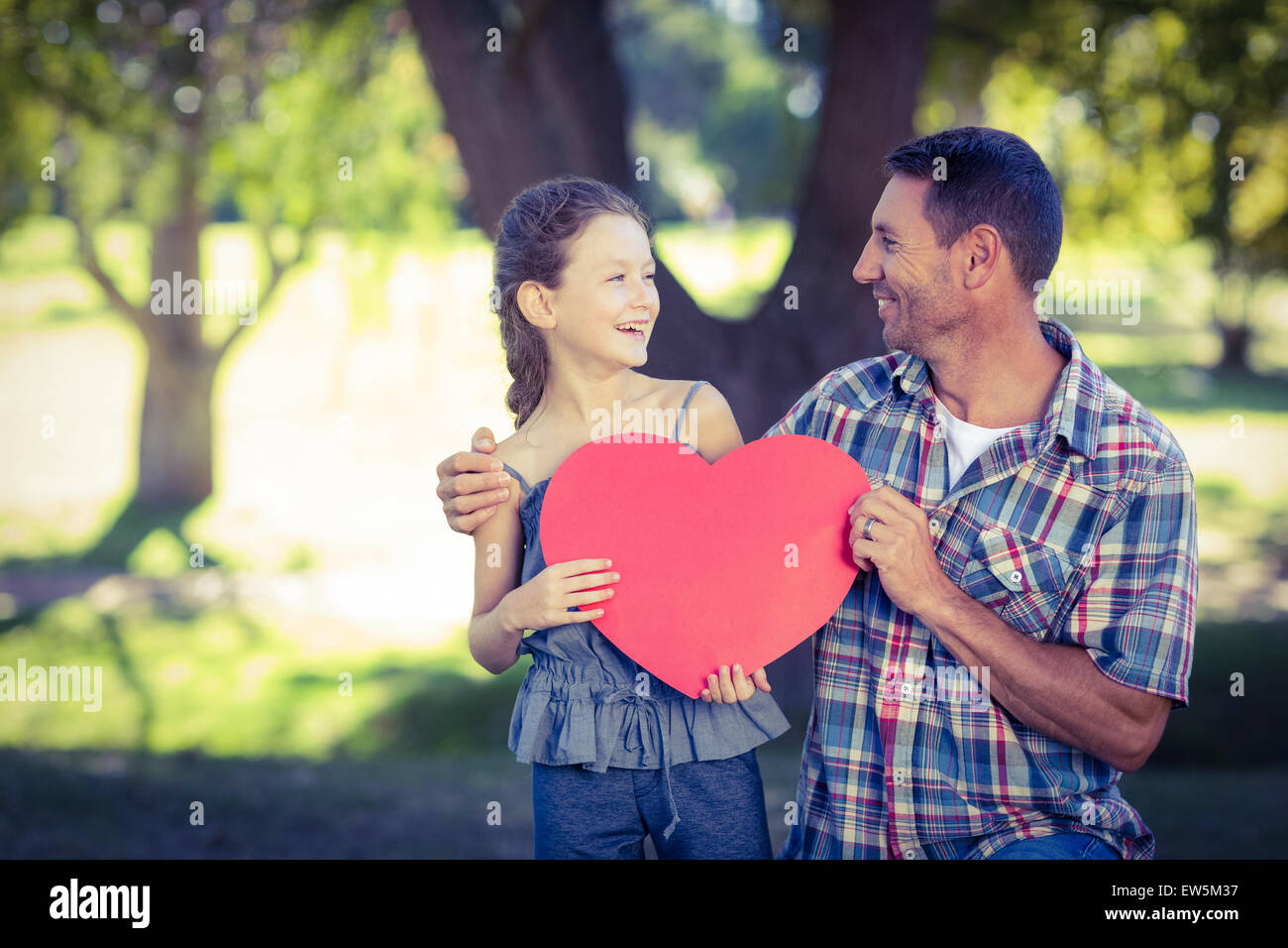 Father and daughter holding a heart in the park Stock Photo - Alamy