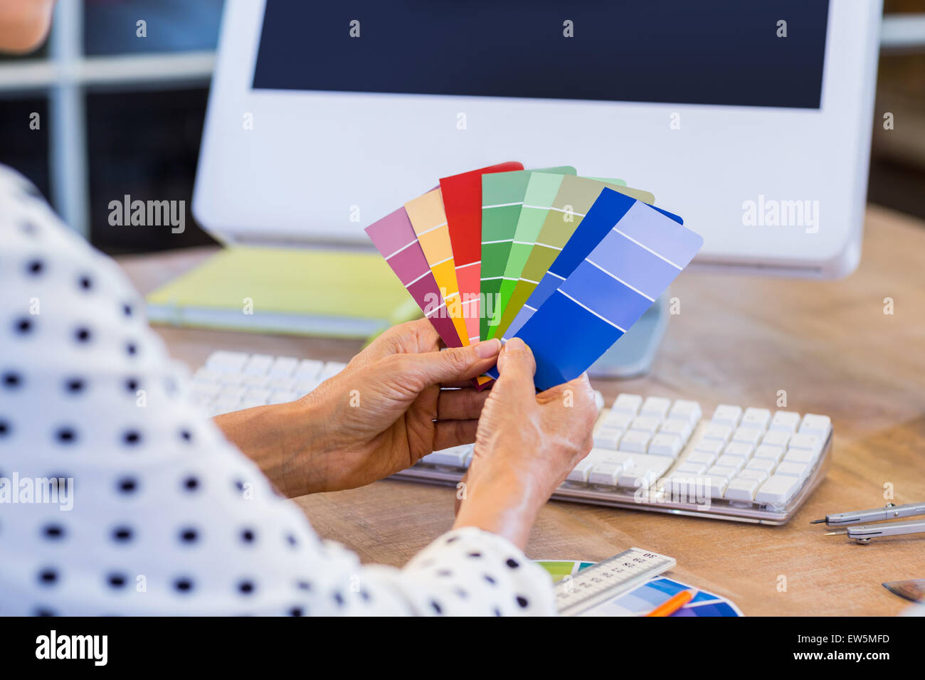 Casual businesswoman looking at colour swatch Stock Photo