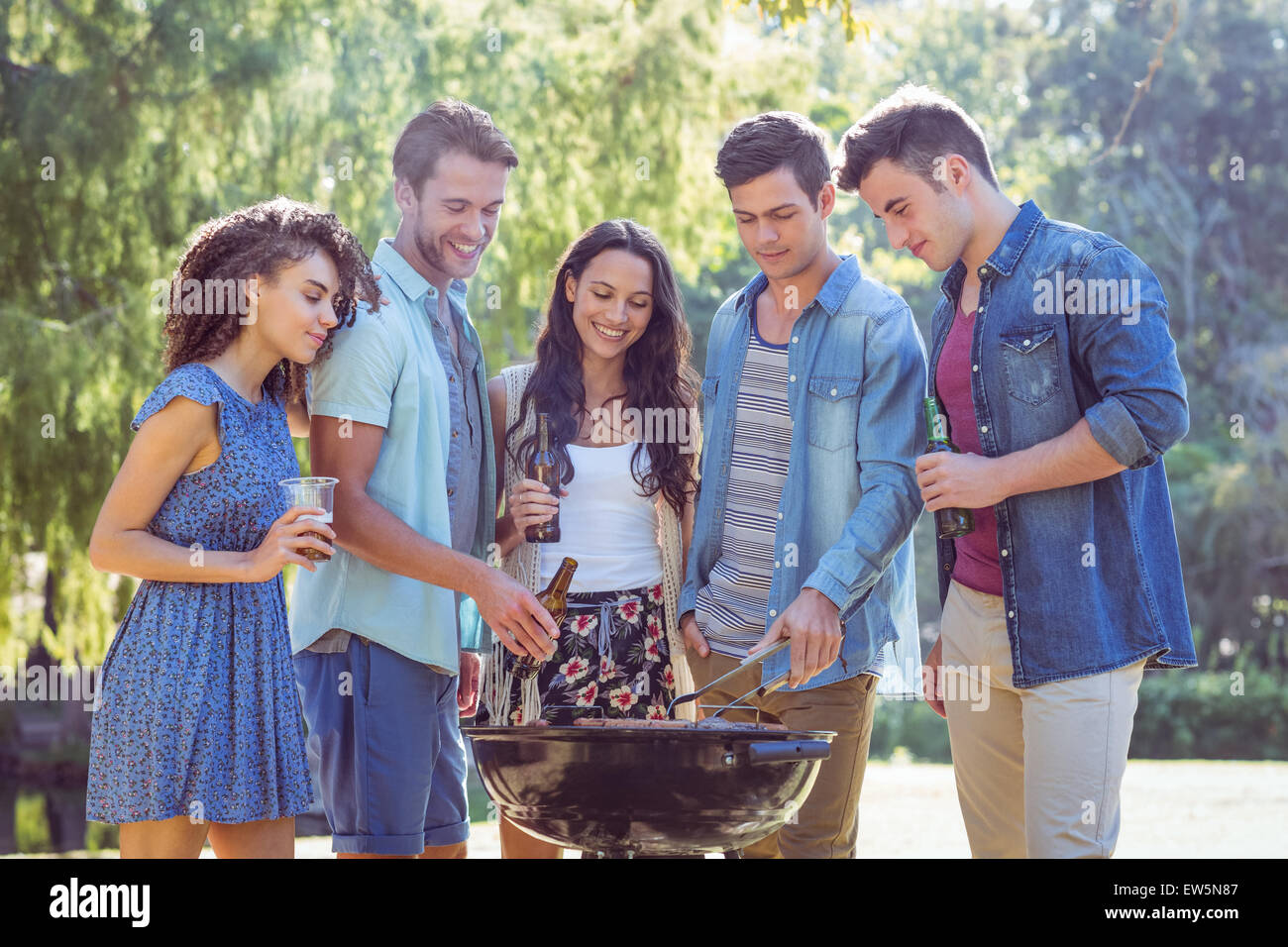 Happy friends in the park having barbecue Stock Photo - Alamy