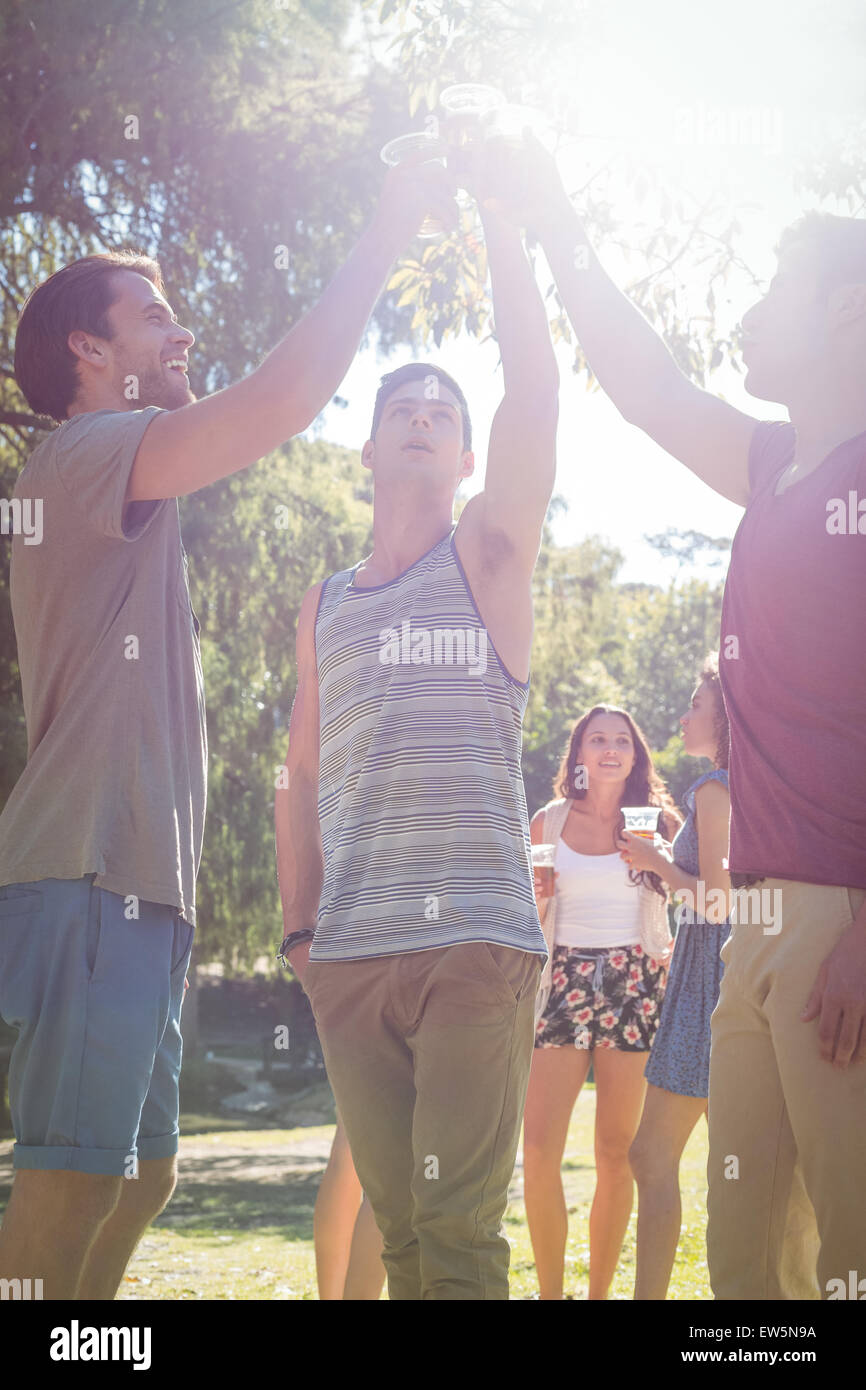 Happy friends in the park having beers Stock Photo - Alamy