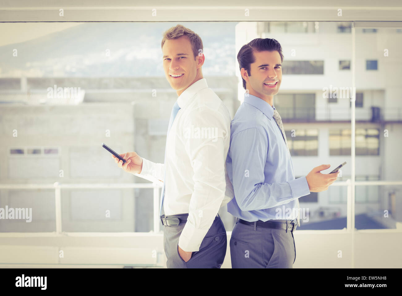 Two businessmen standing back to back Stock Photo - Alamy