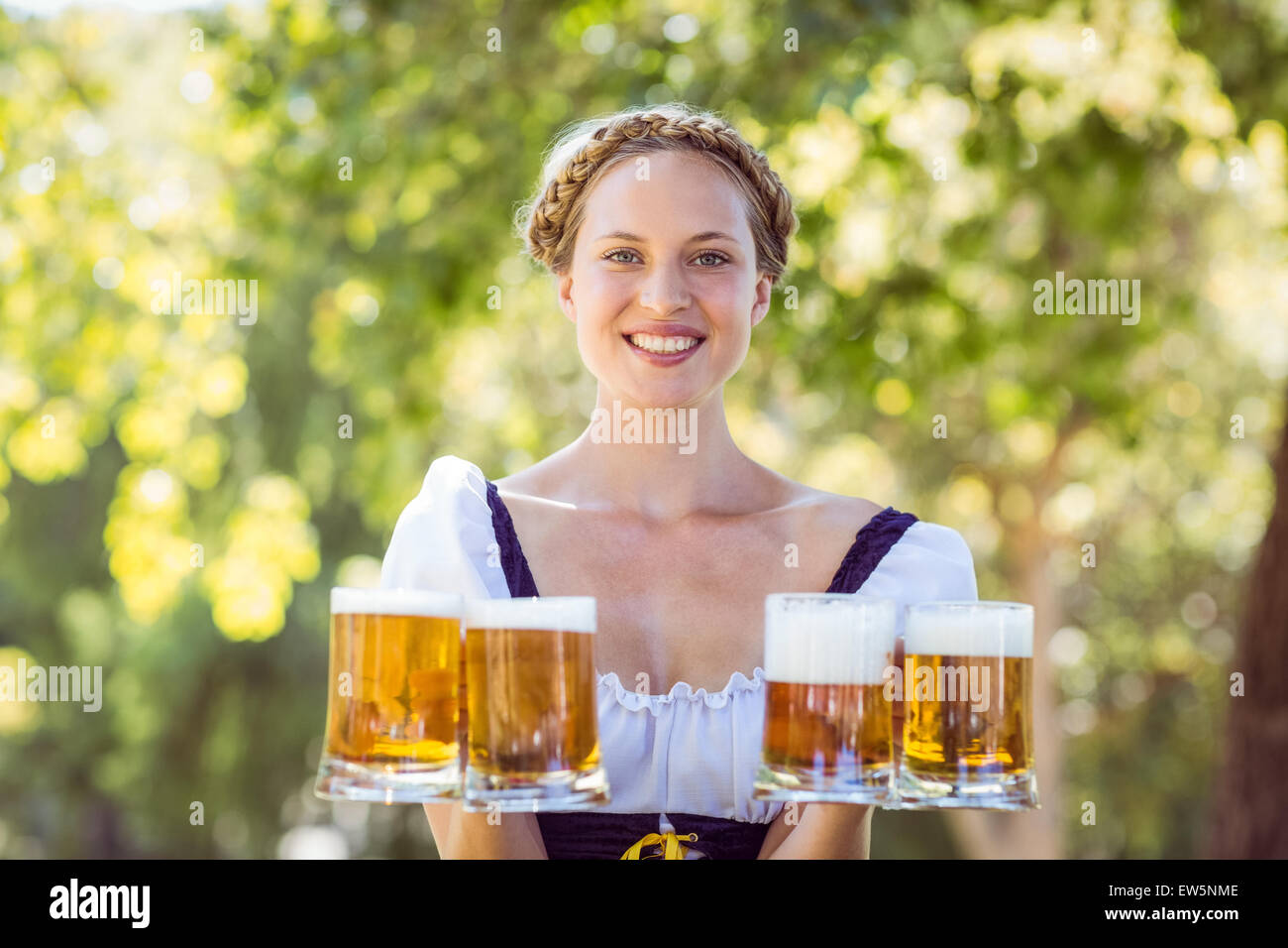 Pretty oktoberfest blonde holding beers Stock Photo - Alamy