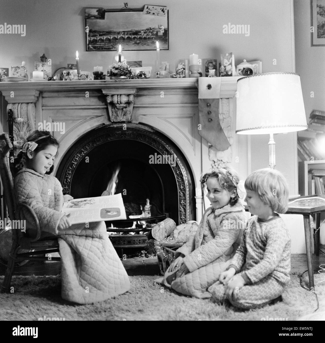 Christmas Eve, Children reading bedtime stories as they wait for Santa, Newcastle, Tyne and Wear. Posed picture taken 18th December 1974. Stock Photo