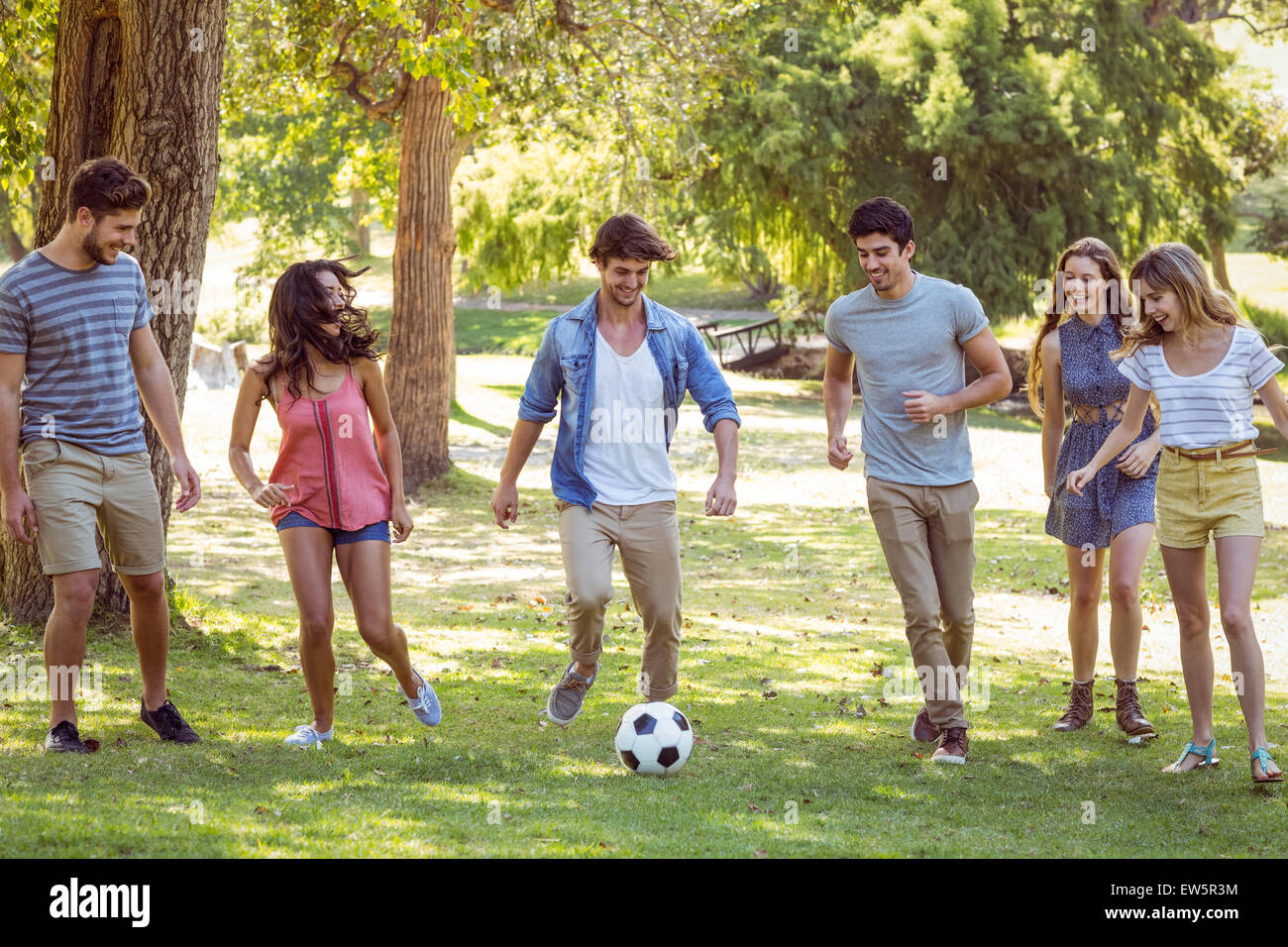 Happy friends in the park with football Stock Photo