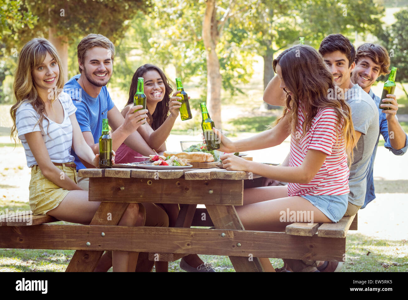 Happy friends in the park having lunch Stock Photo - Alamy