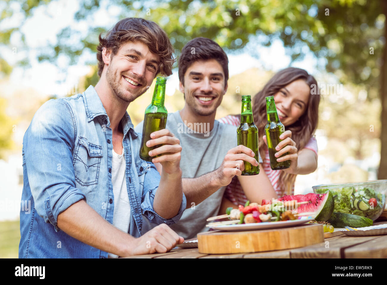 Happy friends in the park having lunch Stock Photo - Alamy