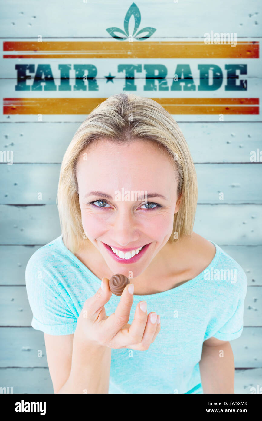 Composite image of smiling blonde holding box of chocolates Stock Photo