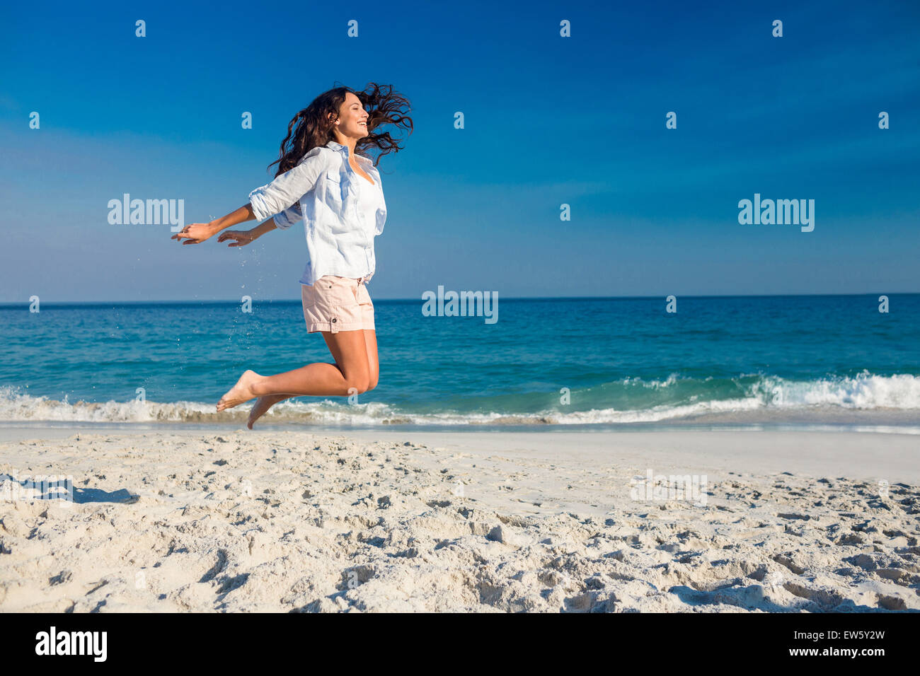 Happy woman jumping on the beach Stock Photo Alamy
