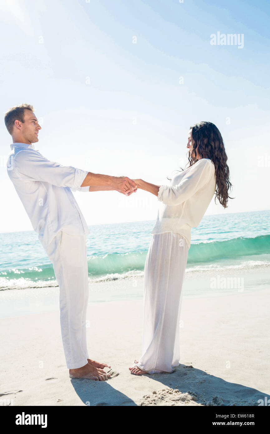 Couple holding hands and standing at beach Stock Photo - Alamy