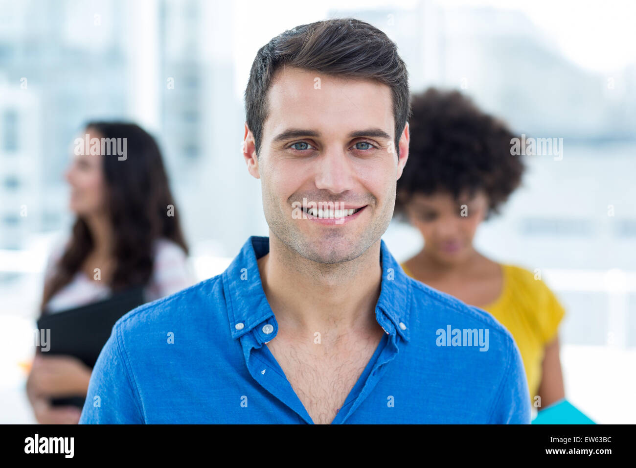 Smiling businessman with his colleagues behind Stock Photo - Alamy