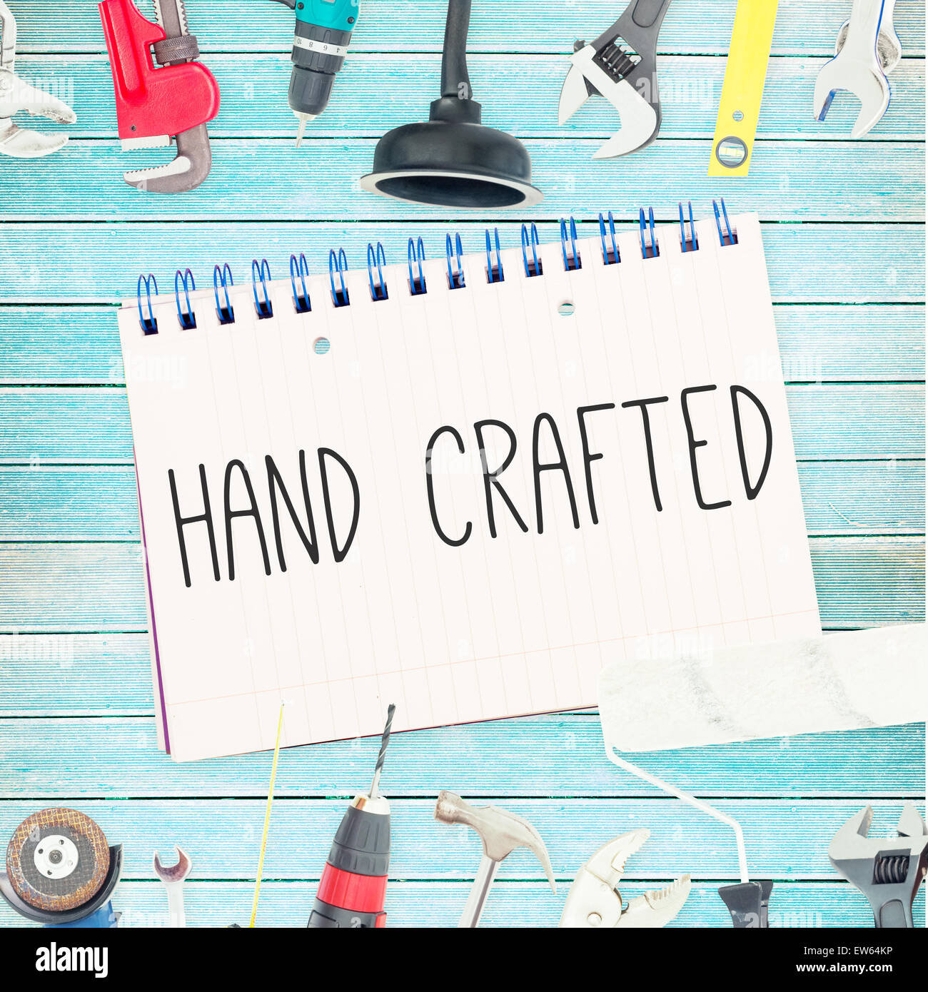 Hand crafted against tools and notepad on wooden background Stock Photo