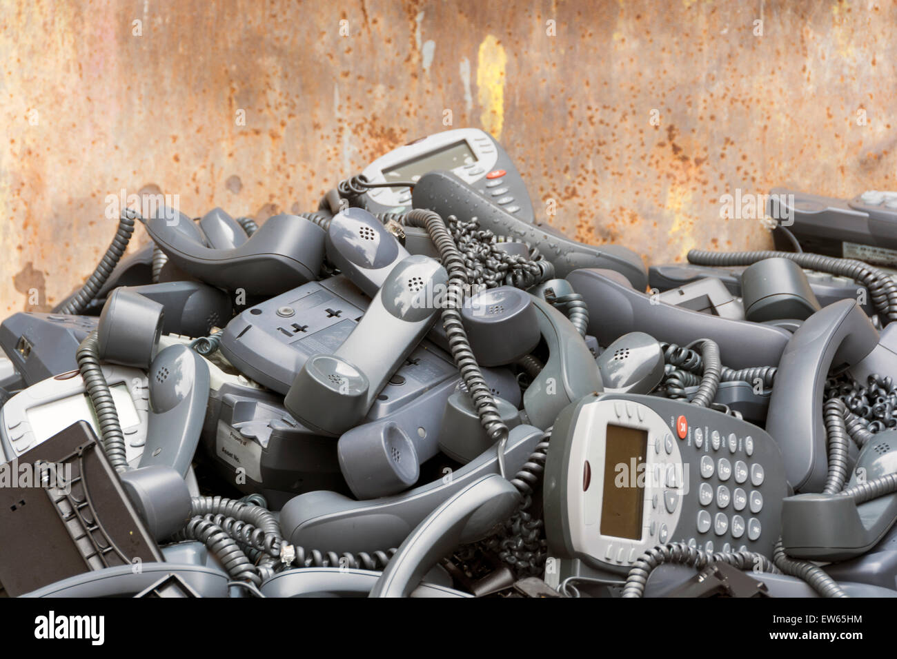 A skip full of electronic goods, mostly telephone sets, that have been stripped from a nearby office building. Stock Photo