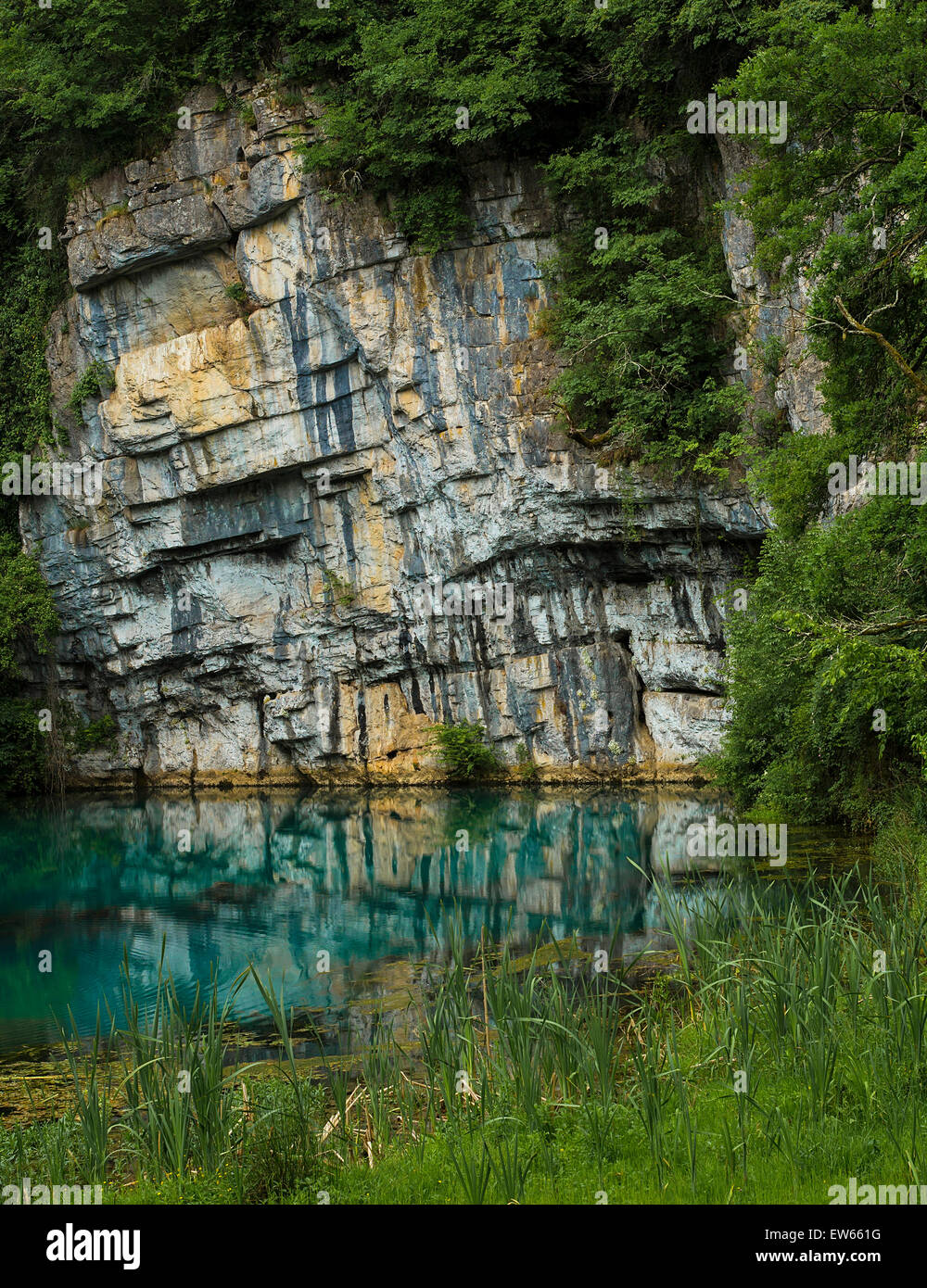 Fresh water source below a huge rock, located in Krupa, Slovenia. Stock Photo