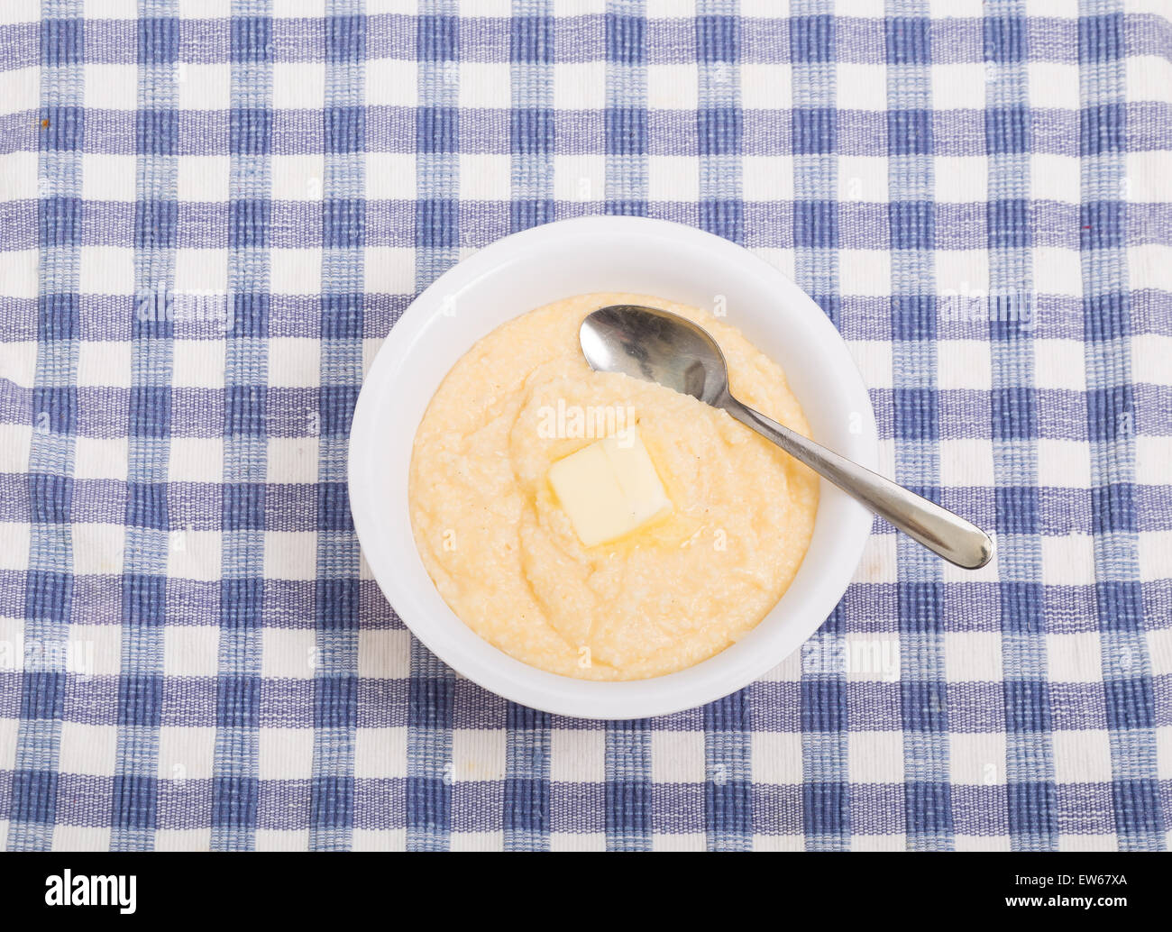 A bowl of hot, yellow grits with a pat of butter melting Stock Photo