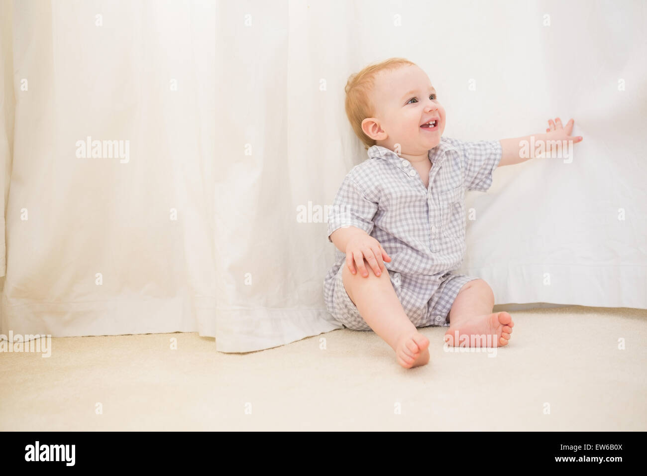 Cute baby boy sitting on floor Stock Photo - Alamy