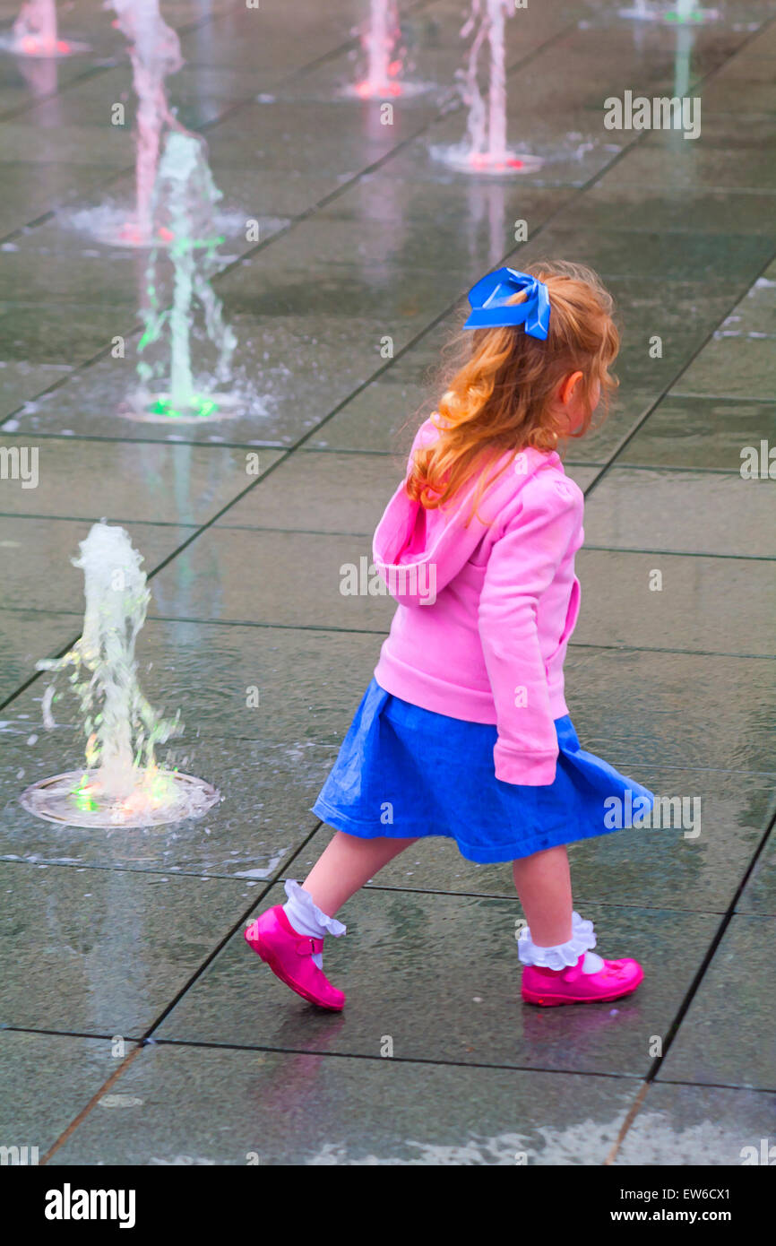 Painterly effect of young girl playing in water feature at Brewery Square, Dorchester South, Dorset in June Stock Photo