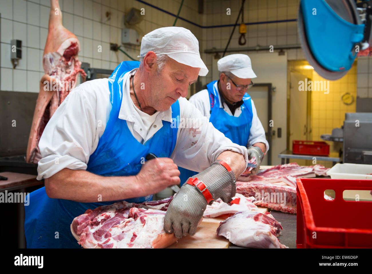 Two butchers cutting pork meat at the butchery Stock Photo