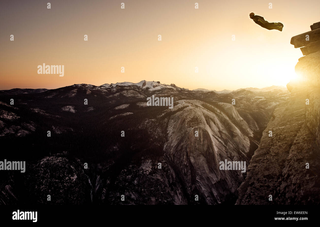 A wingsuiter jumps off Half Dome at sunrise in Yosemite Park, California USA Stock Photo