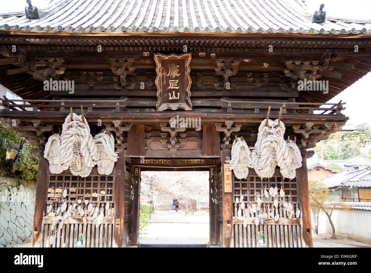 Japan, Onomichi, Saikokuji Temple. Massive straw sandals, owaraji, waraji, hanging from the wooden Deva gate, with many smaller ones hanging below. Stock Photo