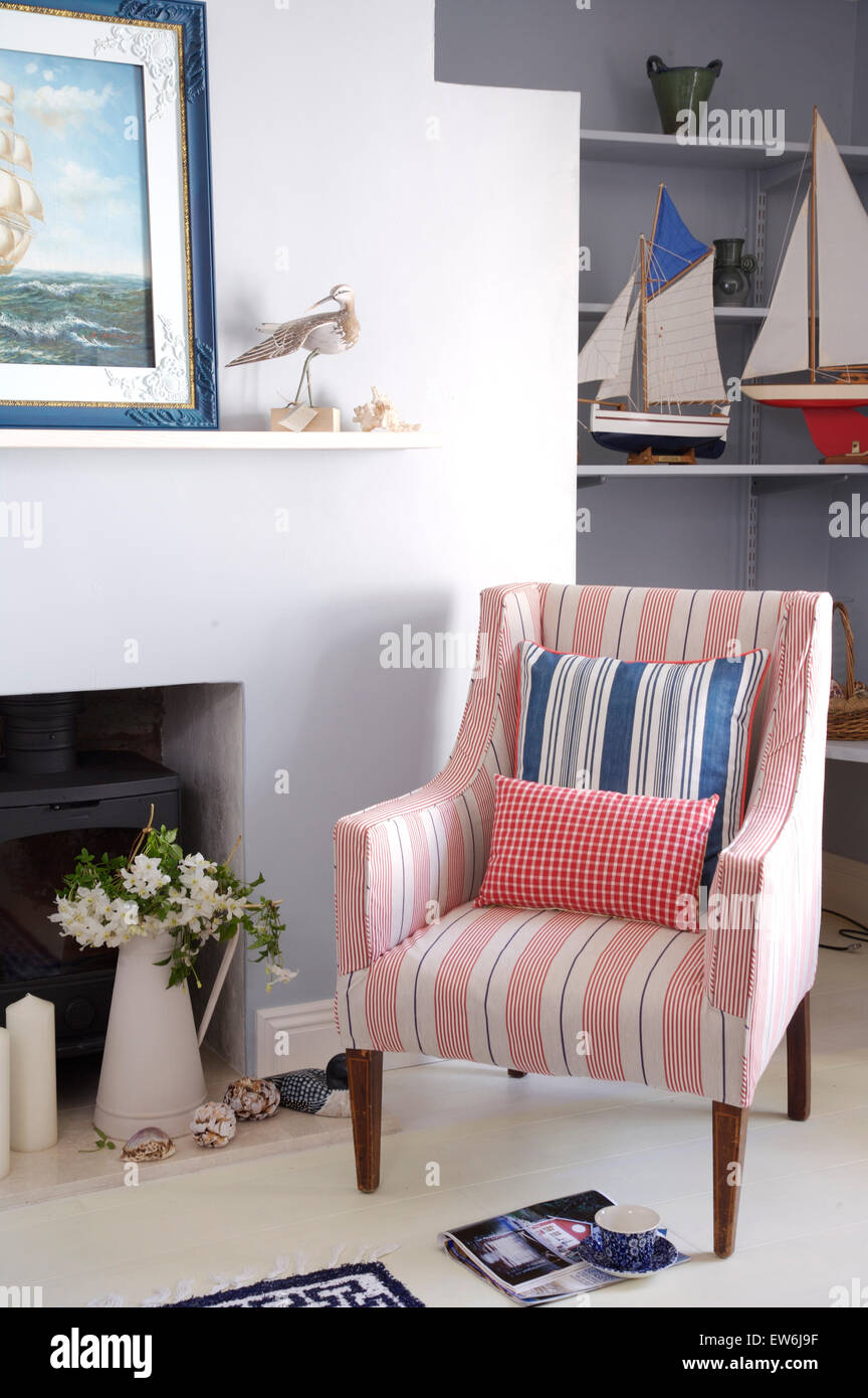 Pink striped chair beside fireplace in coastal cottage sitting room Stock Photo Alamy