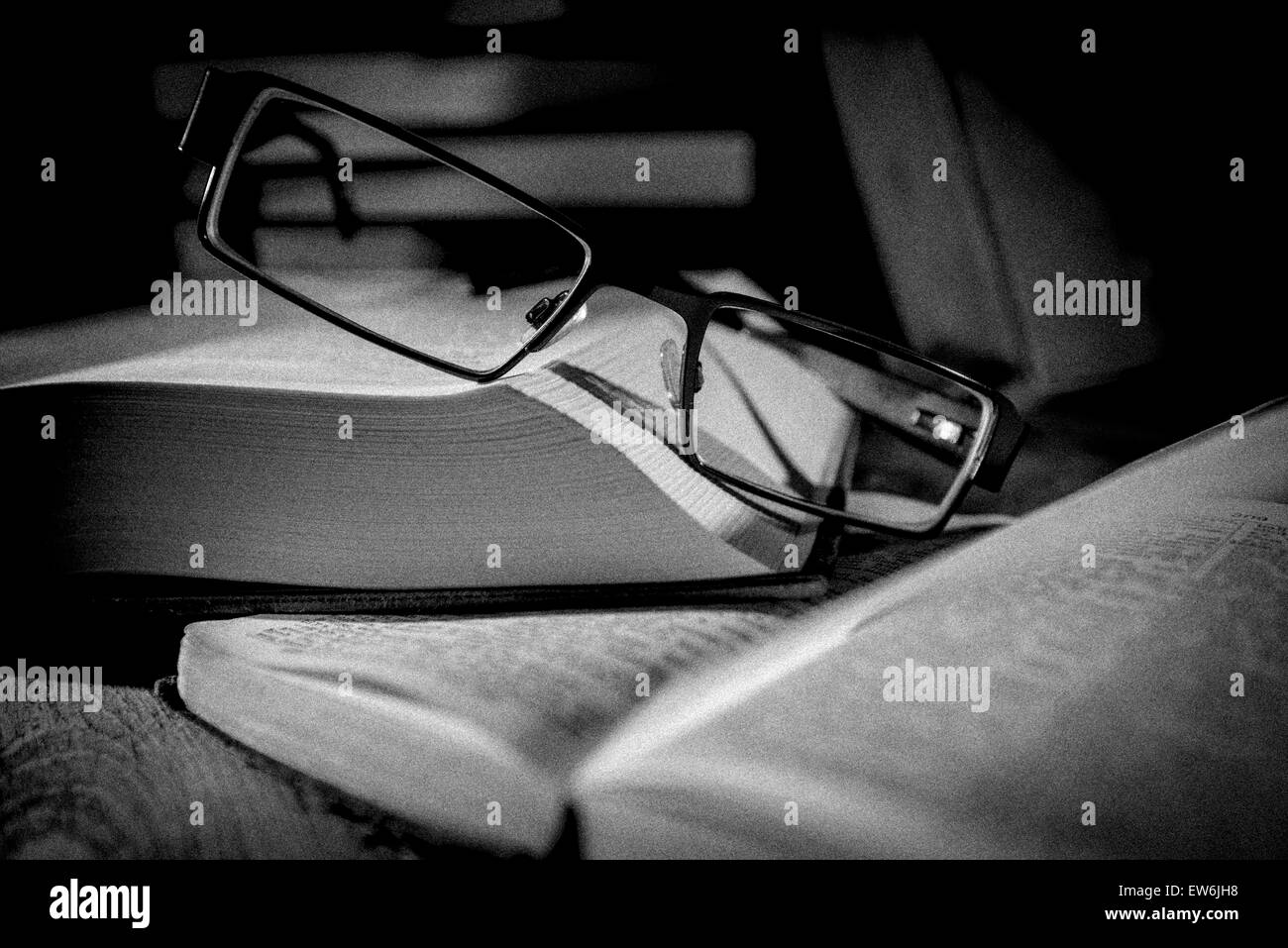 Glasses resting on open books Stock Photo