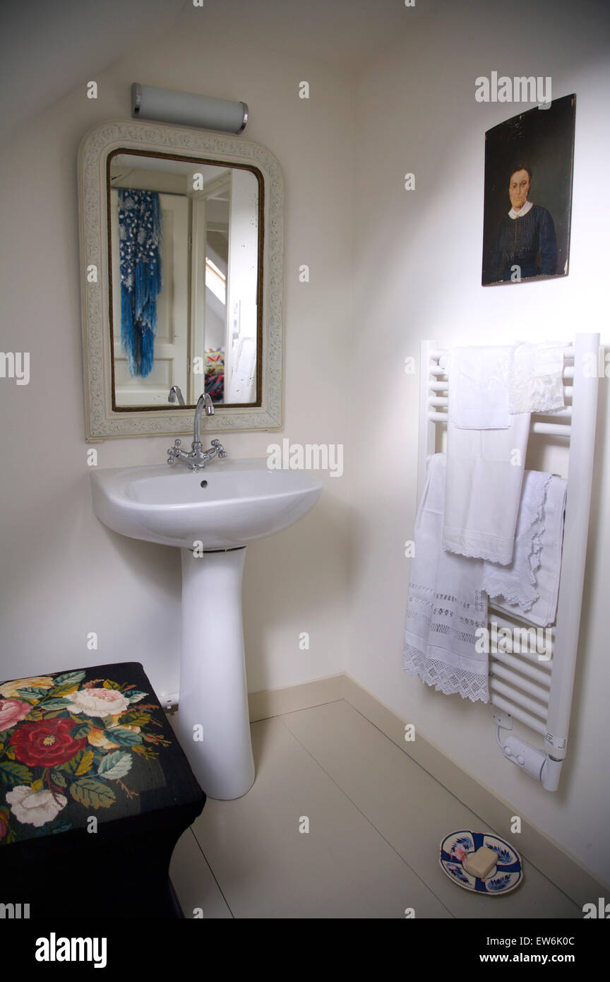 Mirror Above Pedestal Basin In White Cottage Bathroom With A Wall Mounted Heated Towel Rail Stock Photo Alamy