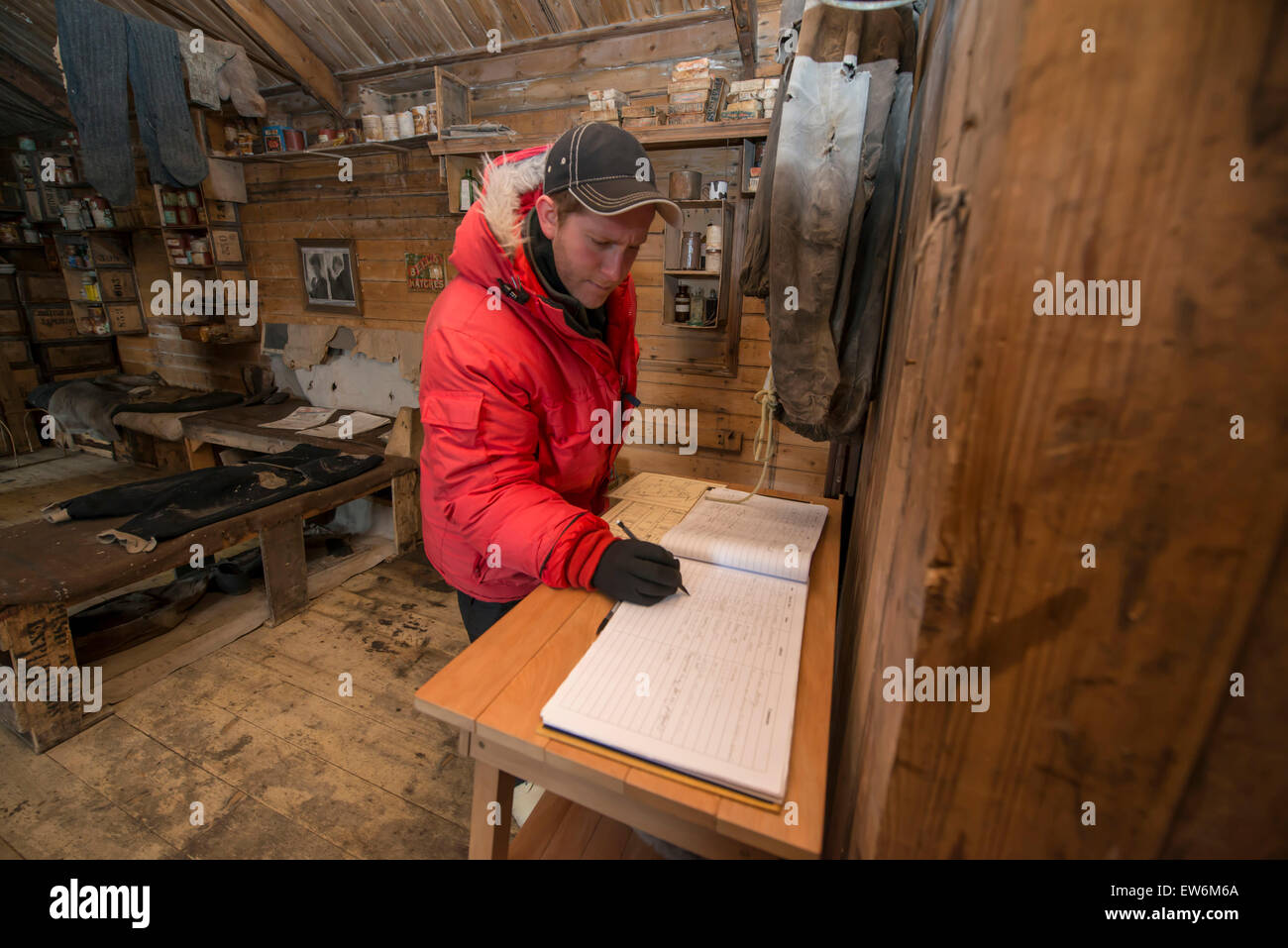 Signing the guest book inside Earnest Shackletons Hut at Cape Royds, Antarctica. Stock Photo