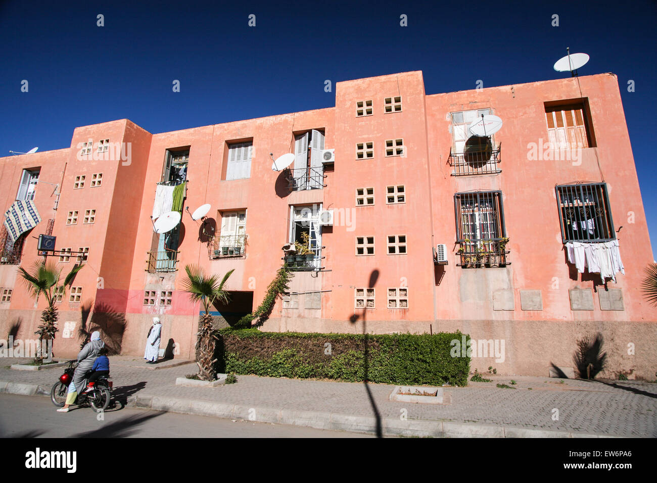 Local women outside satellite dish covered local apartment building in Marrakesh/ Marrakech, Morocco, Africa. Stock Photo