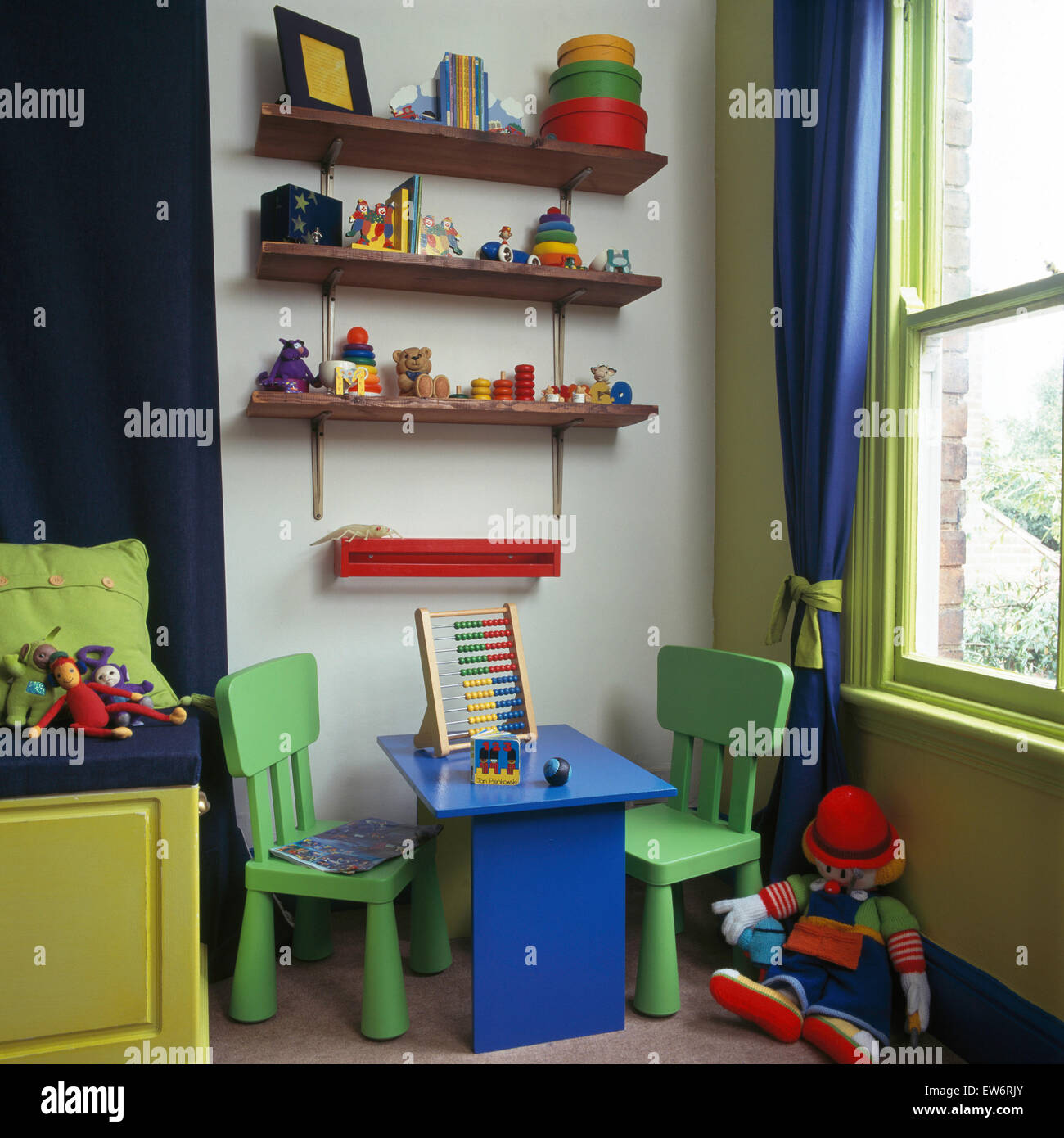 Toys On Shelves Above Child Sized Colorful Table And Chairs In