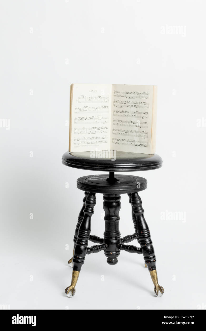 An antique music black bench with a music book open Stock Photo